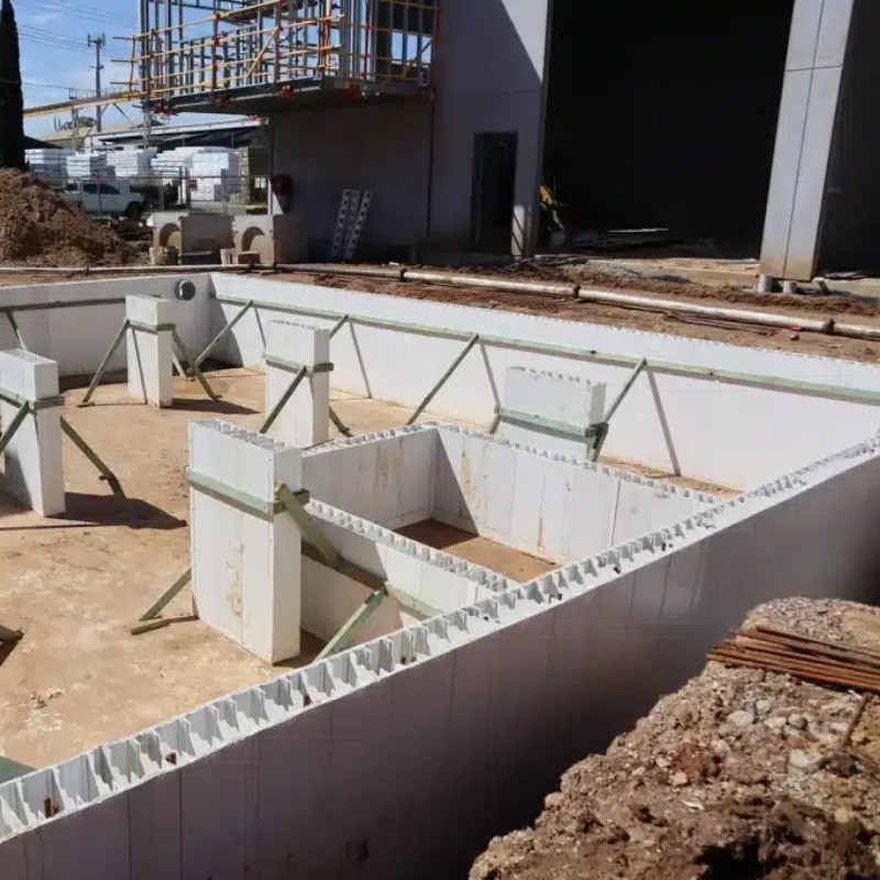 Rise wall application using insulated concrete formwork panels installed on construction site foundation with bracing supports
