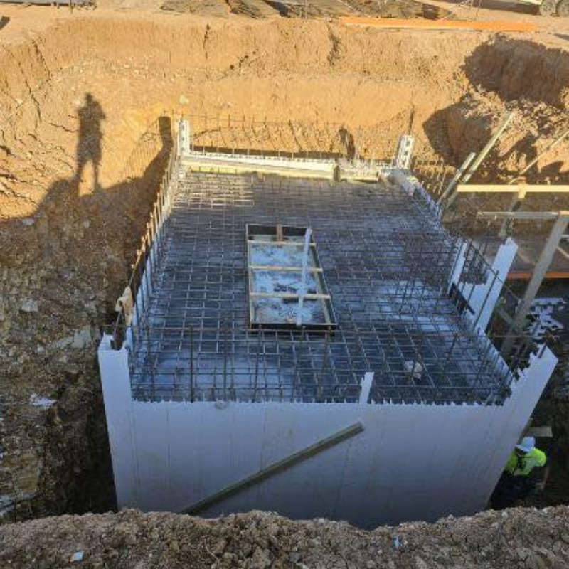 What is formwork showing reinforced concrete foundation walls, steel rebar grid and temporary moulds before concrete pour.